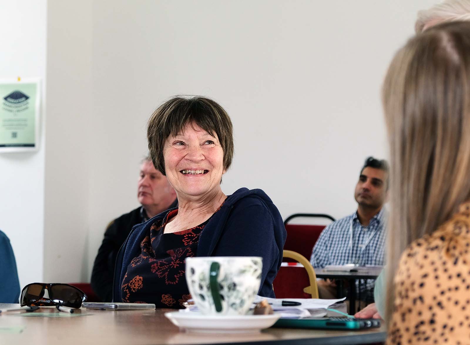 A woman at a community event writing ideas on paper